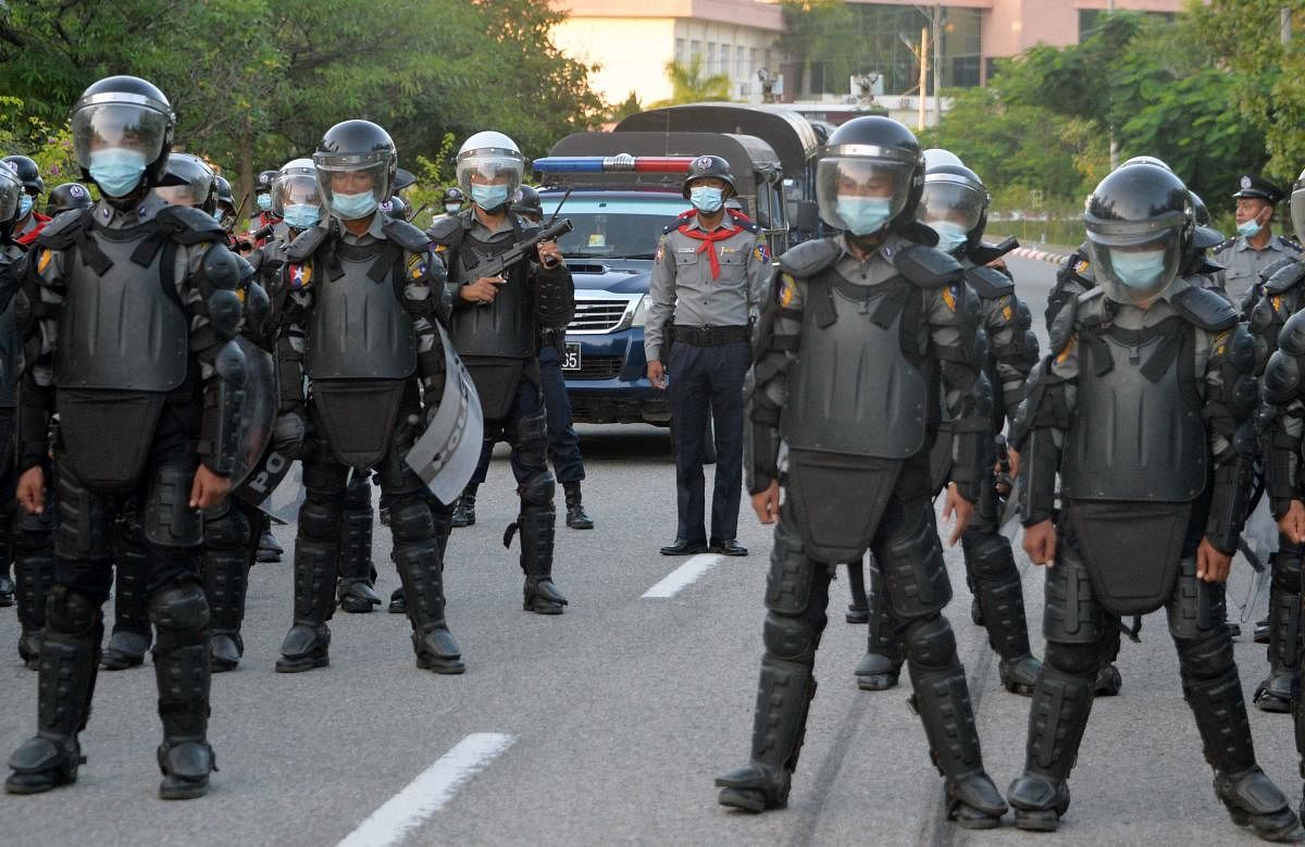 Myanmar police stand guard in front of the Union Election Commission building after protesters held a rally demanding a new election in Naypyidaw on November 11, 2020. (Photo by Thet Aung / AFP)