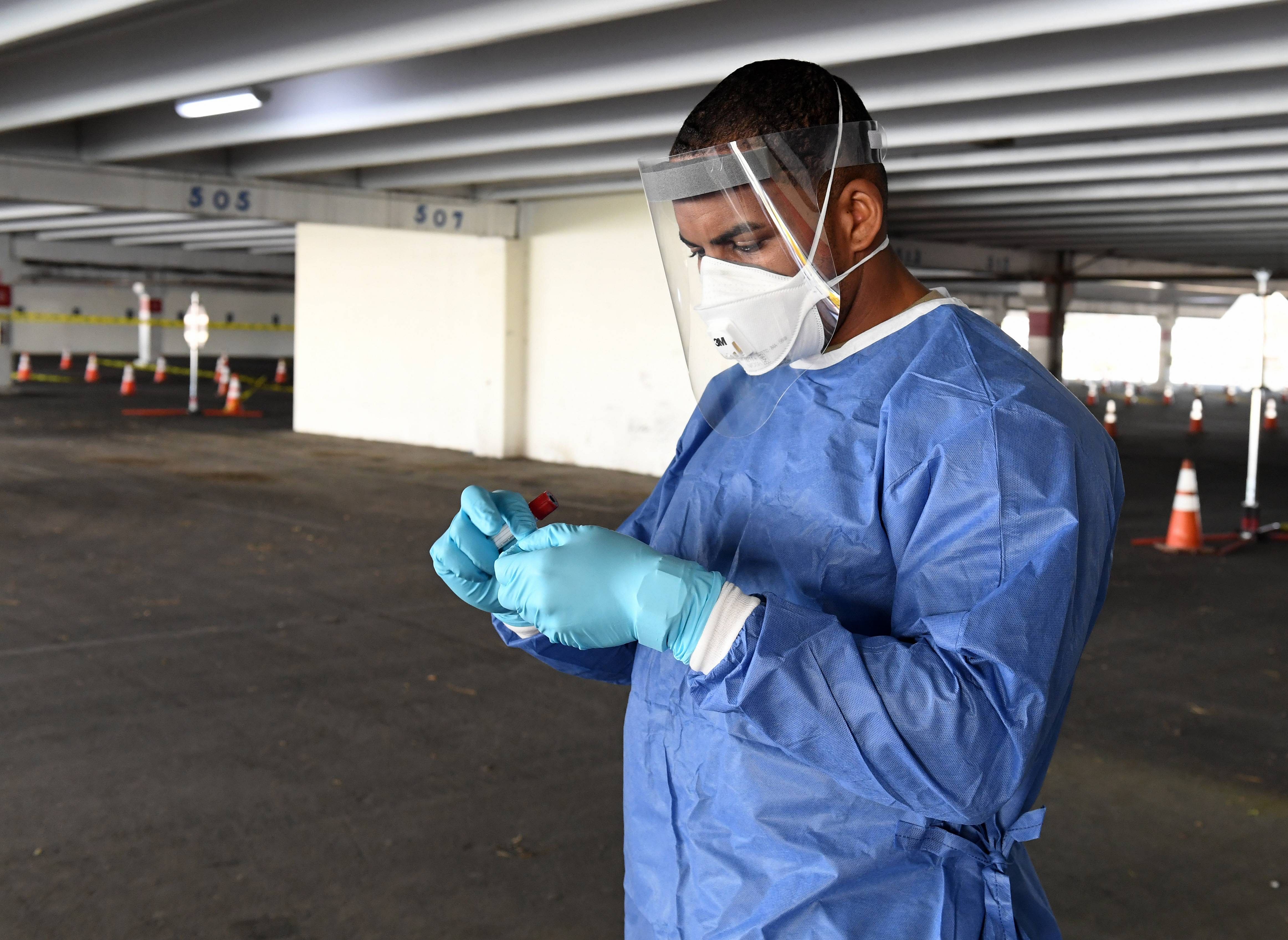 Demetrie Barnett of the Nevada National Guard gets a coronavirus specimen sampling tube ready as he administers tests during a preview of a free drive-thru Covid-19 testing site in North Las Vegas, Nevada. Credit: Getty Images/AFP