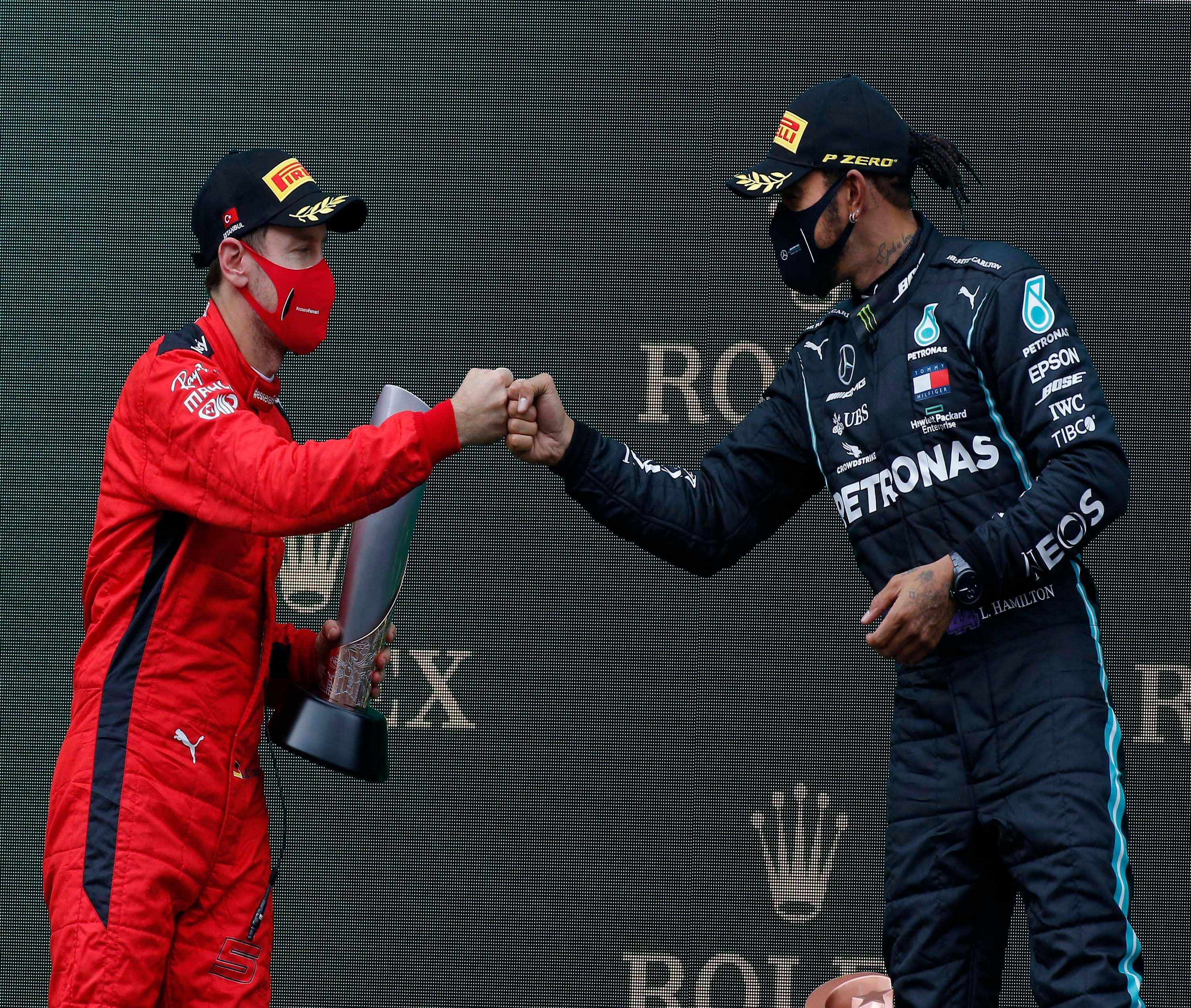  Third placed Ferrari driver Sebastian Vettel of Germany, left, and race winner Mercedes driver Lewis Hamilton of Britain greet each other on the podium of the Formula One Turkish Grand Prix at the Istanbul Park circuit racetrack in Istanbul, Sunday, Nov. 15, 2020. Racing Point driver Sergio Perez of Mexico finished second. Credit: AP/PTI Photo