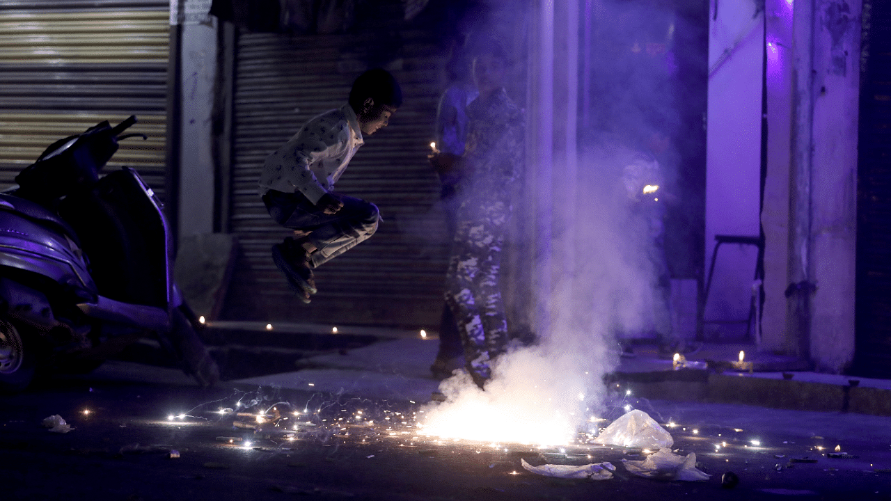 People watch as firecrackers burn during Diwali, the Hindu festival of lights, in New Delhi. Credits: Reuters Photo