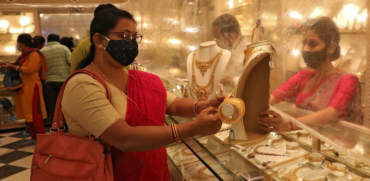 Woman looks at a gold necklace at a jewellery showroom during Dhanteras, a Hindu festival associated with Lakshmi, the goddess of wealth, amidst the spread of Covid-19 in Kolkata. Credit: Reuters Photo