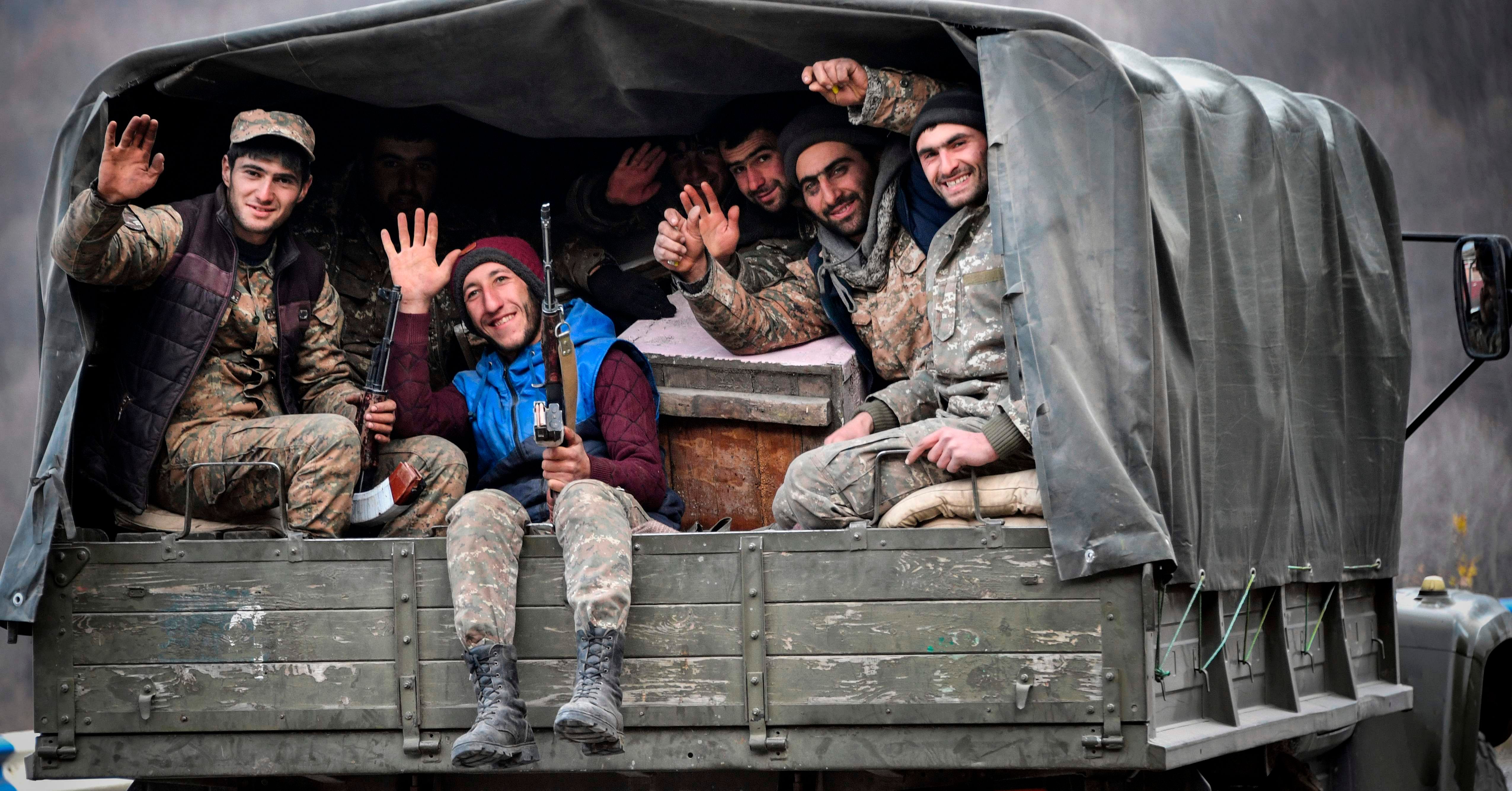 Armenian soldiers sit in the back of a truck as they drive along a road outside Kalbadjar on November 15, 2020. - Azerbaijan said on November 15, 2020, it had agreed to extend a deadline for Armenia to withdraw from a disputed district as part of a peace accord that ended six weeks of fierce fighting over the Nagorno-Karabakh region. Armenia lost around 2300 dead during the military conflict over this breakaway region.Credit: AFP Photo