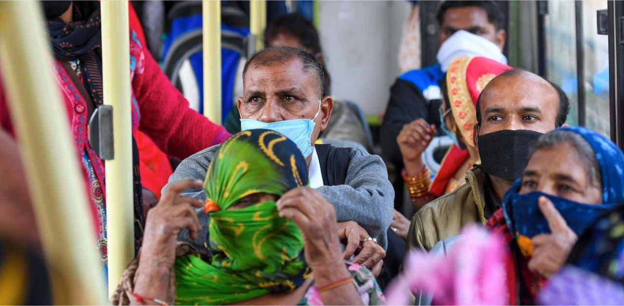 People wearing facemasks as a preventive measure against the Covid-19 travel in a bus in New Delhi. Credit: AFP