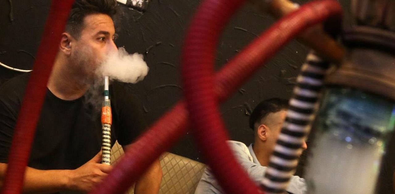 Iraqi men smoke narguileh (water pipe) at a coffee shop in Iraq's central holy city of Karbala. Credit: AFP