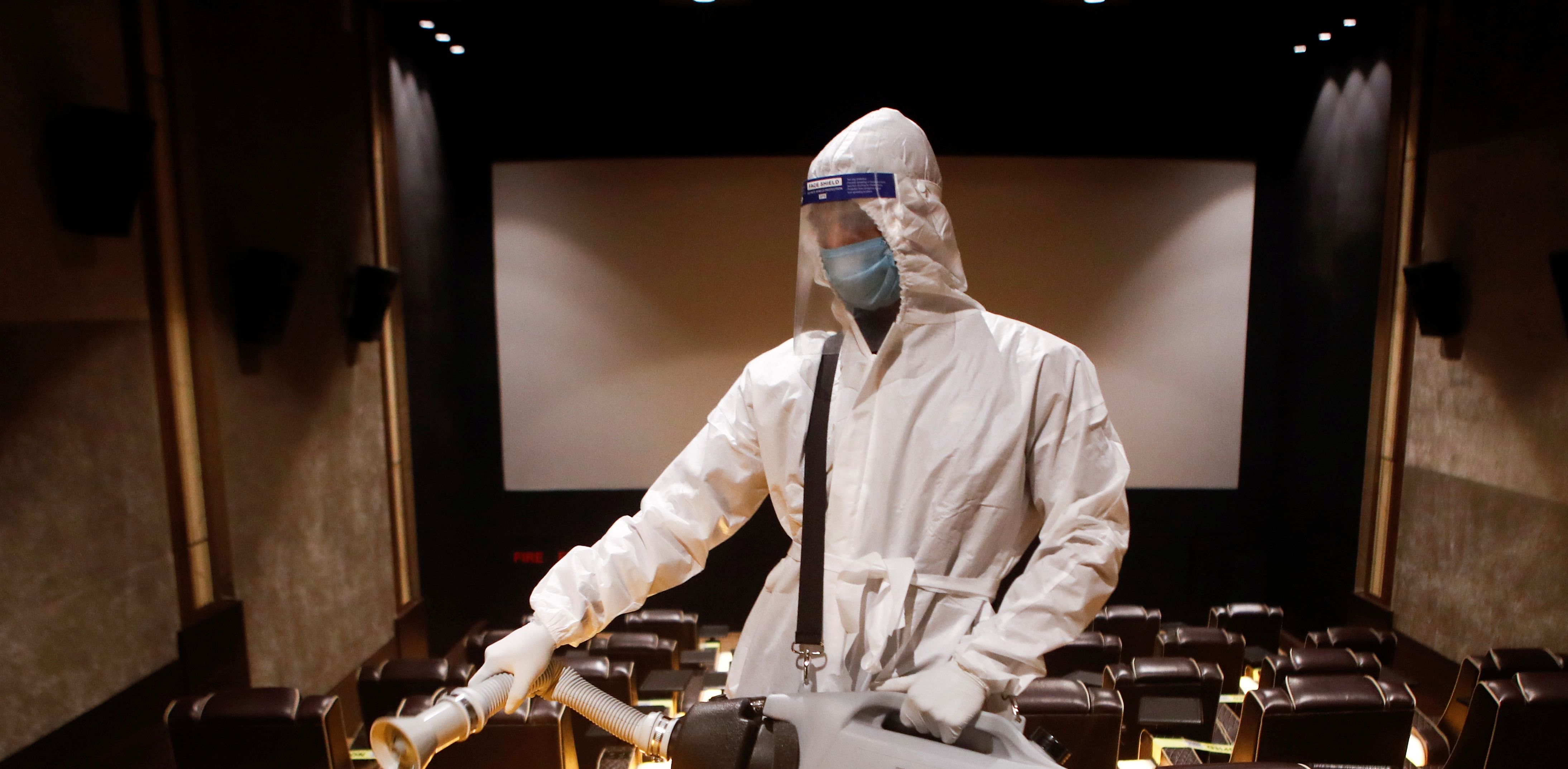 A man in PPE sanitizes a cinema hall before a movie amid the spread of the coronavirus disease in Mumbai. Credit: Reuters