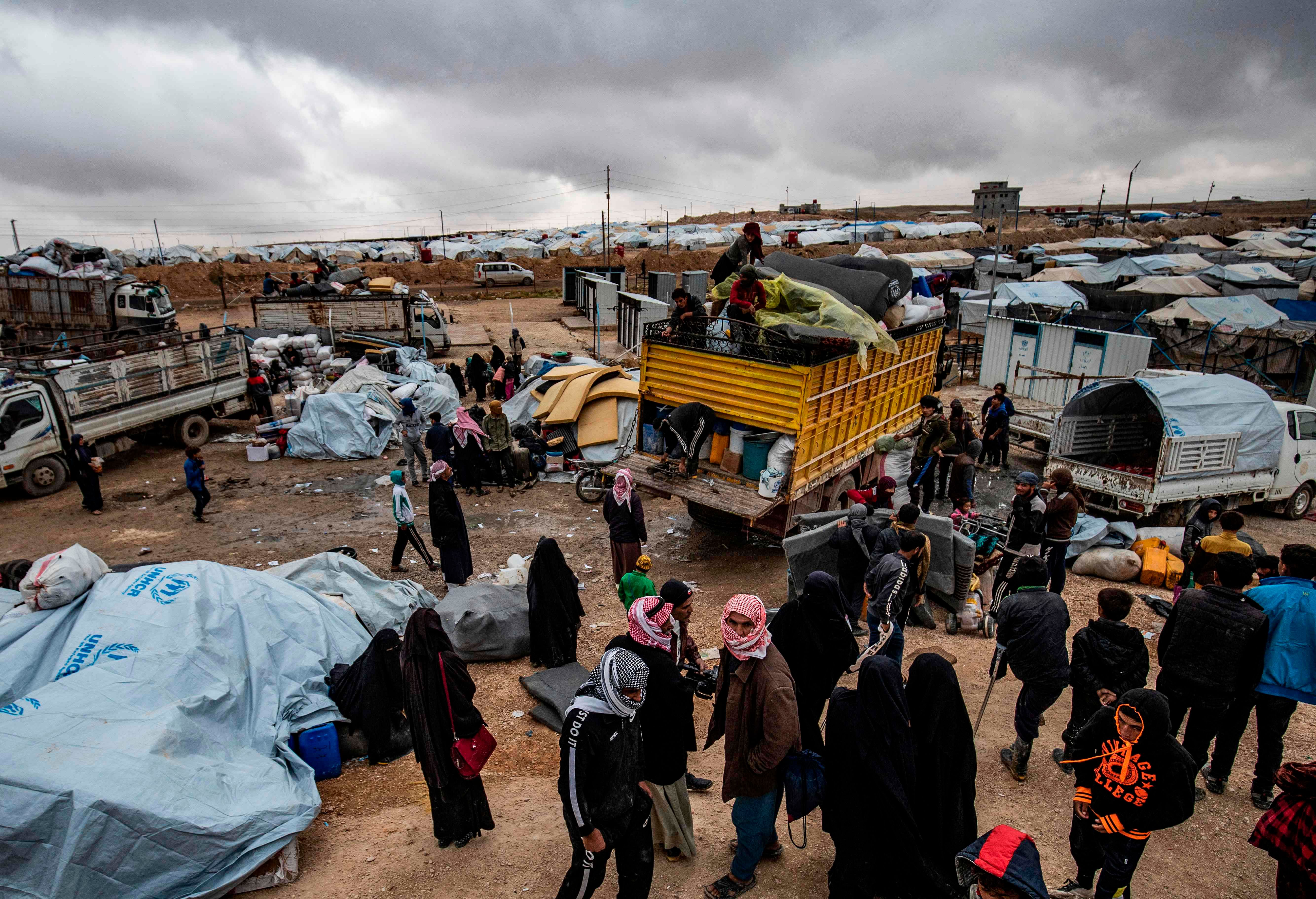 Syrians load their belongings onto trucks as they prepare to leave the Kurdish-run al-Hol camp holding relatives of alleged Islamic State (IS) group fighters, in the al-Hasakeh governorate in northeastern Syria, on November 16, 2020. - A Kurdish official in charge of the region's camps, said 515 people from 120 families were returning to areas in the east of Deir Ezzor province, the first to do so after the Kurdish authorities in northeast Syria vowed to allow thousands of Syrians including the families of IS fighters out of the over-populated camp. Credit: AFP Photo