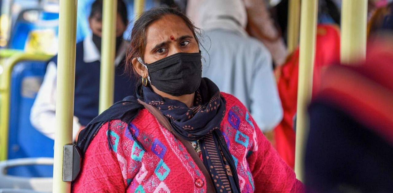 A woman wearing a facemask as a preventive measure against the Covid-19 coronavirus travels in a bus in New Delhi on November 16, 2020. Credit: AFP Photo