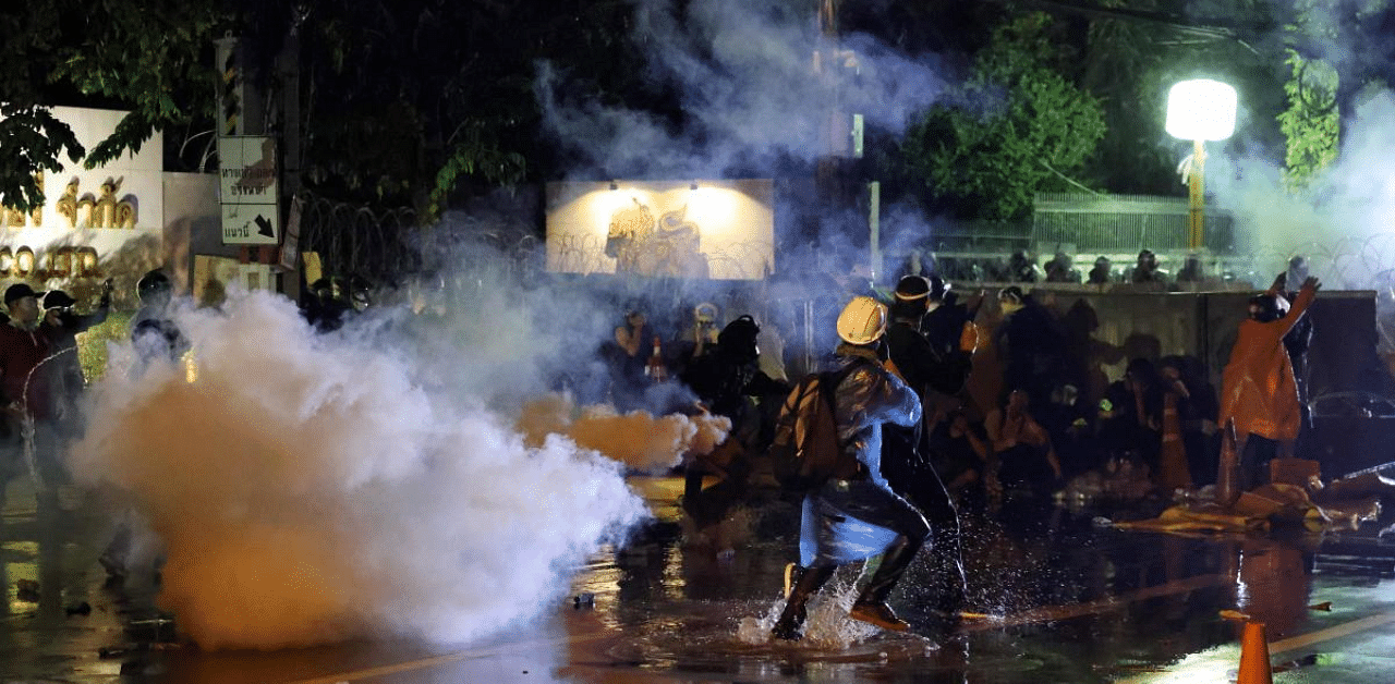 Pro-democracy protesters react as police fire tear gas during an anti-government rally near the Thai Parliament in Bangkok. Credit: Reuters Photo