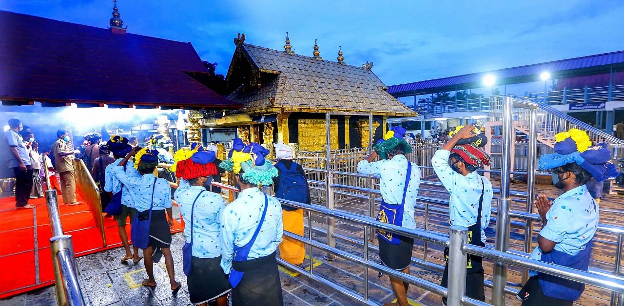 Devotees maintain social distance while standing in queues to offer prayers at Lord Ayyappa temple on the 1st day of Malayalam month of 'Vrischikom, at Sabarimala in Pathanamthitta. Credit: PTI Photo
