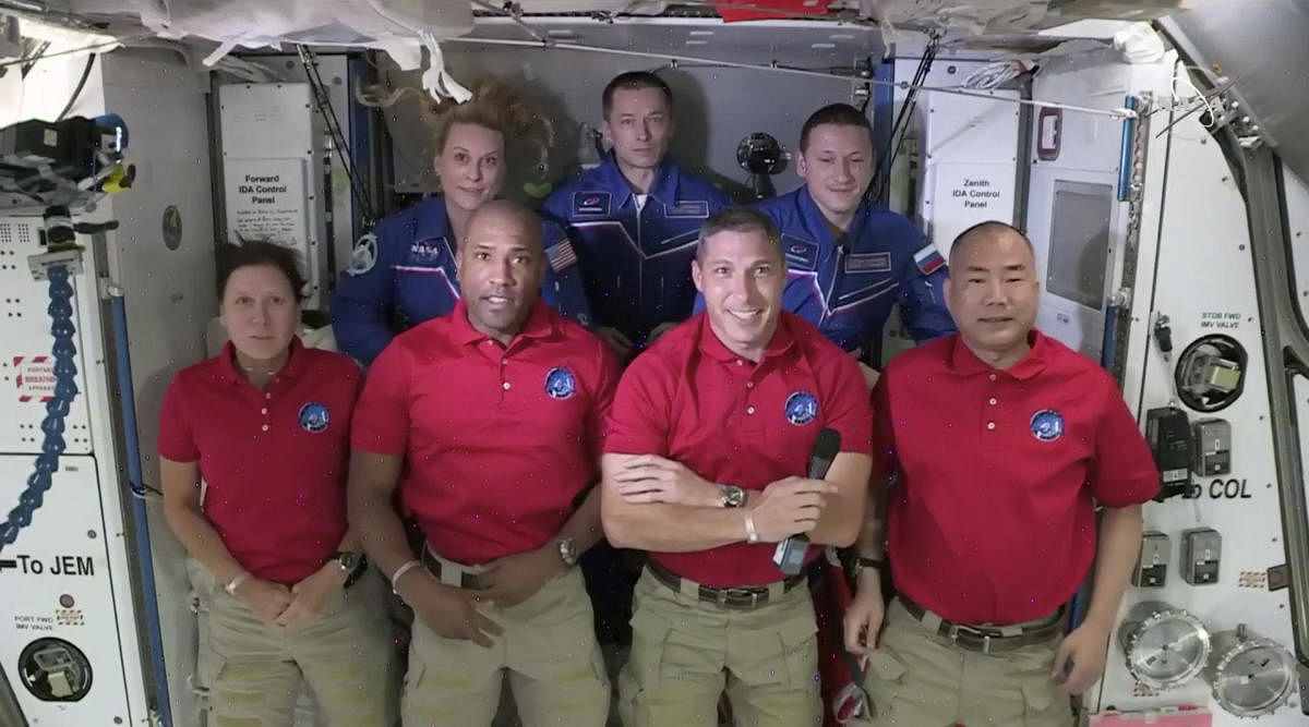 In this frame grab from NASA TV, SpaceX Dragon crew, from front left to right, Shannon Walker, Victor Glover, Mike Hopkins and Soichi Noguchi stand with International Space Station crew Kate Rubins, from back left, Expedition 64 commander Sergey Ryzhikov and Sergey Kud-Sverchkov. Credit: AP