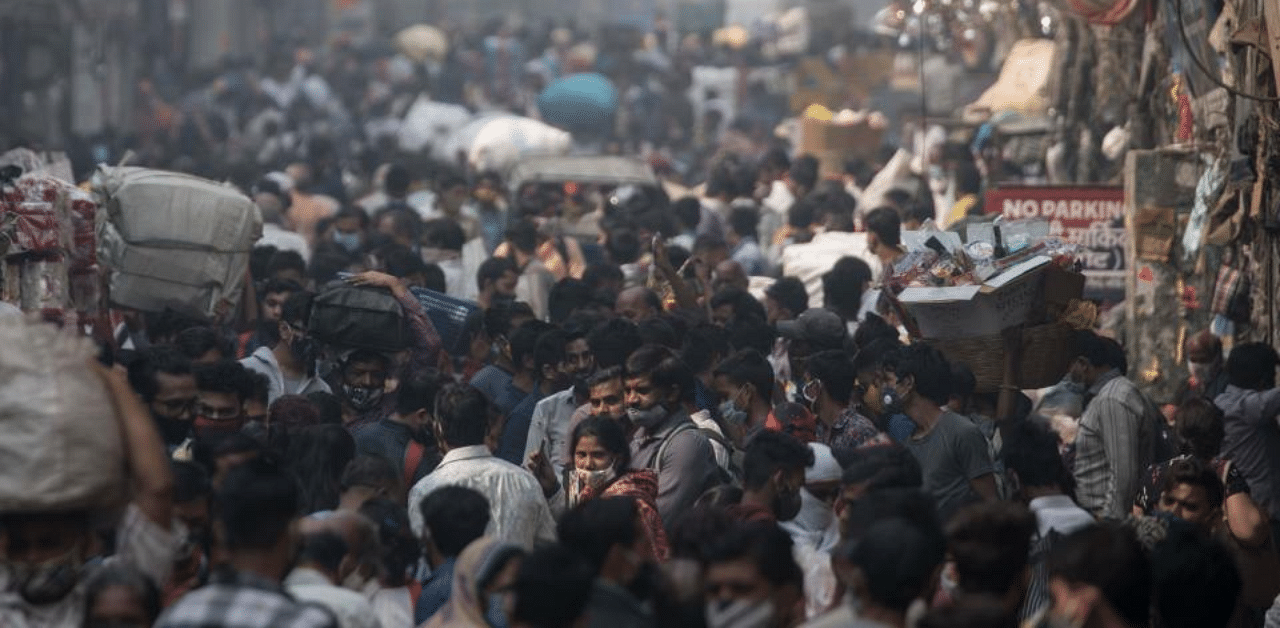 People walk along a street of a market area amid the Covid-19 coronavirus pandemic in New Delhi on November 7, 2020. Credit: AFP Photo