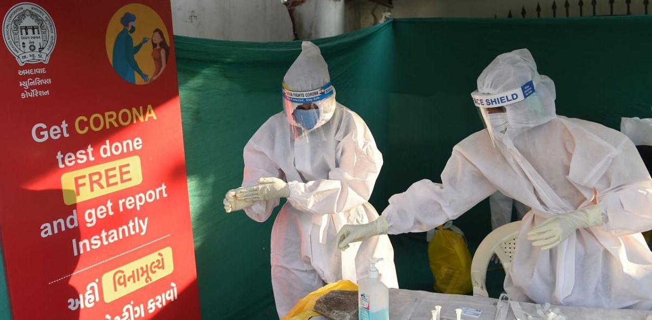 Health workers prepare to take swab sample from residents to test for the Covid-19. Credit: AFP Photo