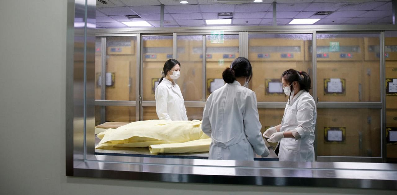 Park Bo-ram, a funeral director, cleans the body of a deceased at a funeral home in a medical center in Seoul, South Korea. Credit: Reuters Photo
