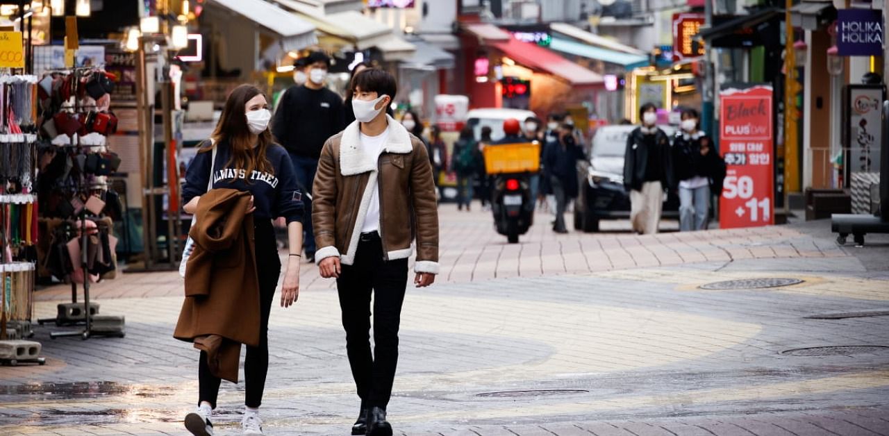 Pedestrians wearing masks walk on a shopping street amid the coronavirus disease in South Korea. Credit: Reuters Photo