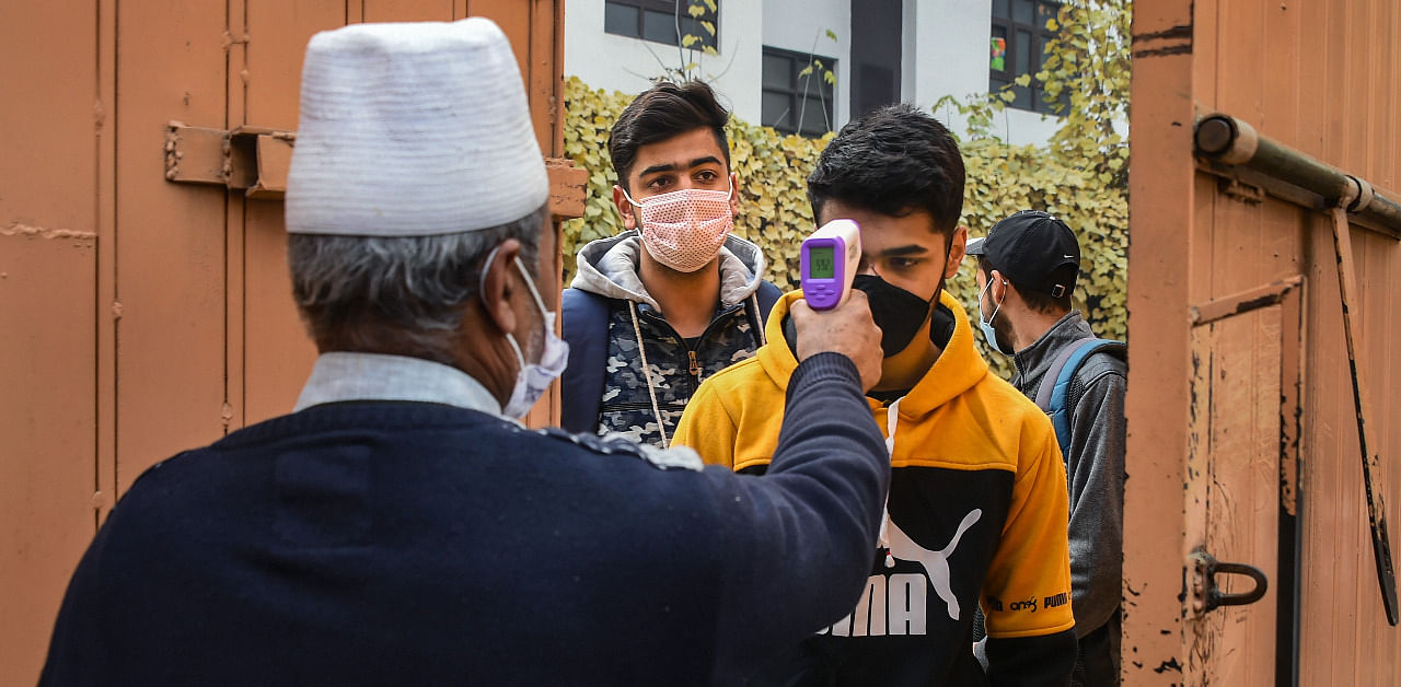 Students undergo thermal screening as they arrive to appear in class 10th examination, at a school in Srinagar. Credit: PTI Photo