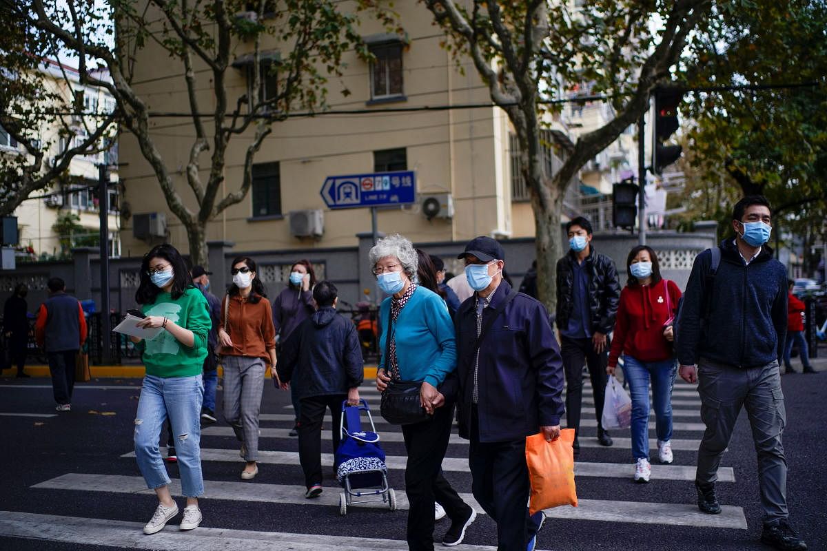 People wearing face masks are seen on a street amid the global outbreak of the coronavirus disease in Shanghai. Credit: Reuters