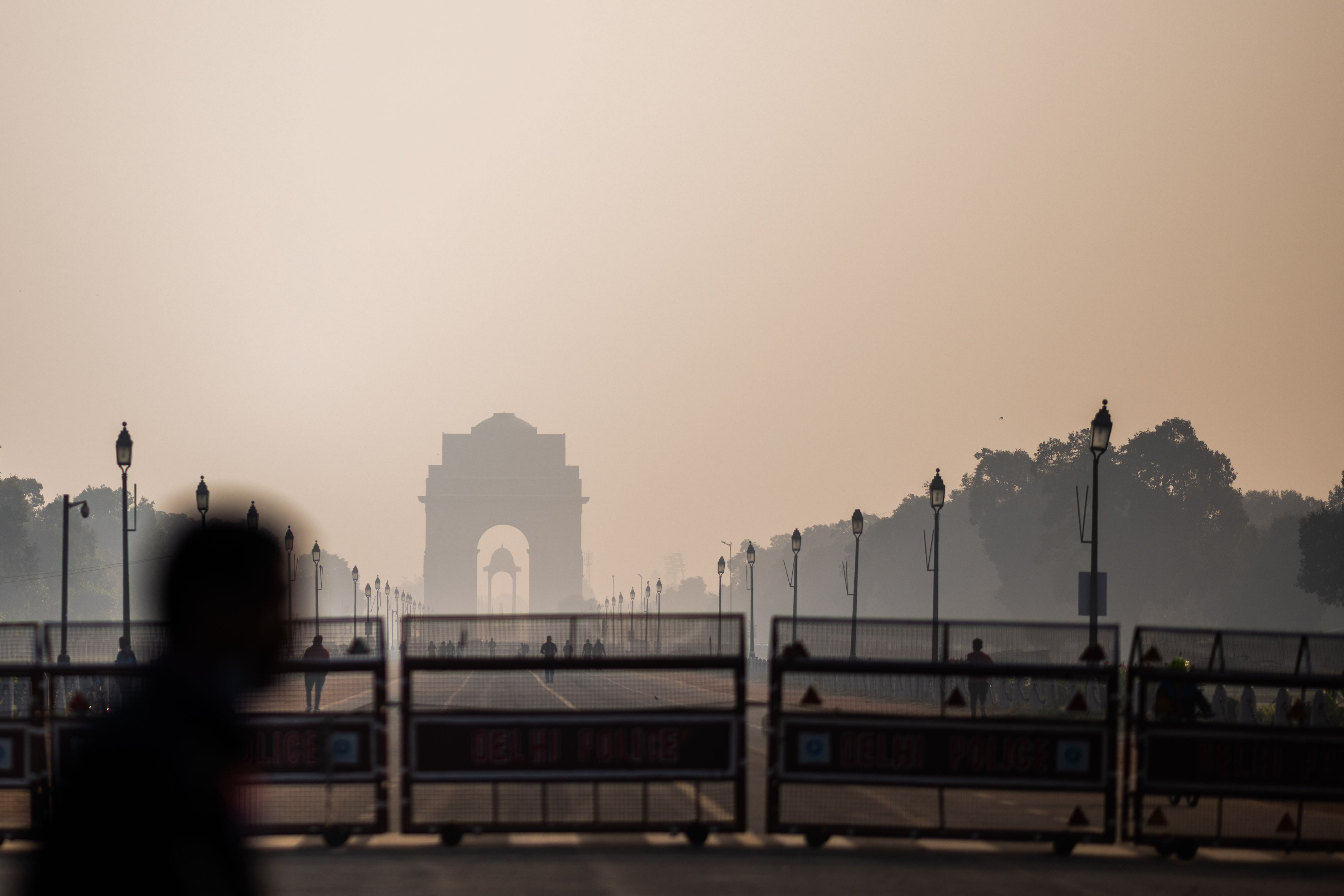 People walk along a street near India Gate amid smoggy conditions in New Delhi. Credit: AFP Photo