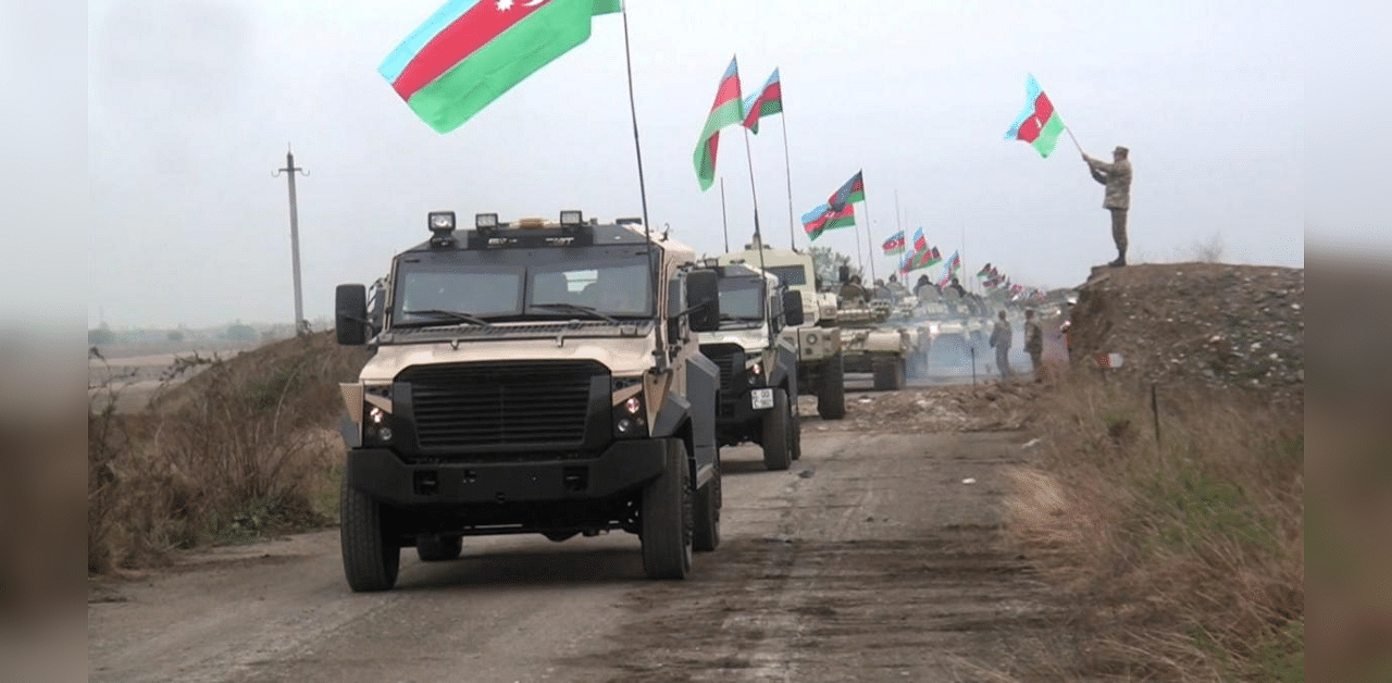 A still image from a video released by Azerbaijan's Defence Ministry shows military vehicles driving along a road as Azerbaijan army units enter the Aghdam region of Nagorno-Karabakh November 20, 2020. Credit: Reuters 