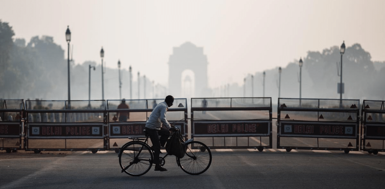 A man rides a bicycle along a street amid smoggy conditions in New Delhi. Credit: AFP Photo