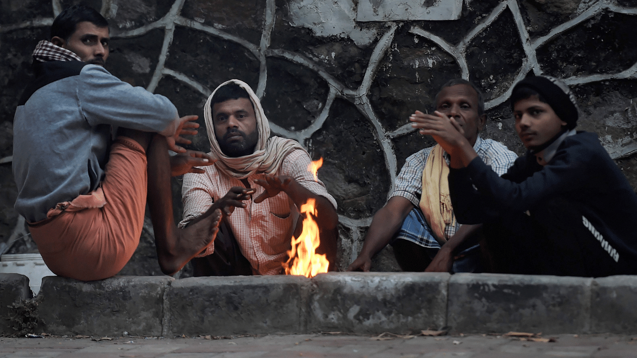 eople sits near a bonfire on a cold morning, amid hazy weather conditions, in New Delhi. Credit: PTI Photo