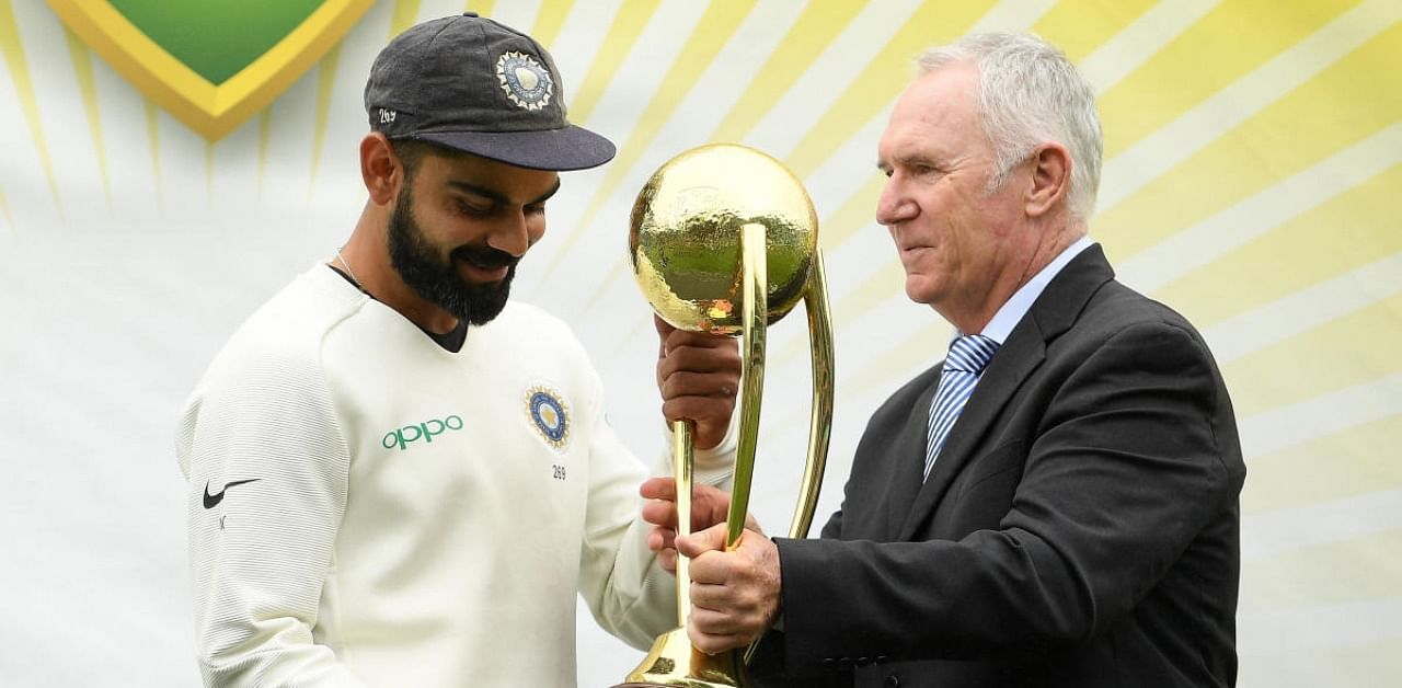 India's captain Virat Kohli recieves the Border-Gavaskar Trophy from Australia's former cricketer Allan Border. Credit: Reuters Photo