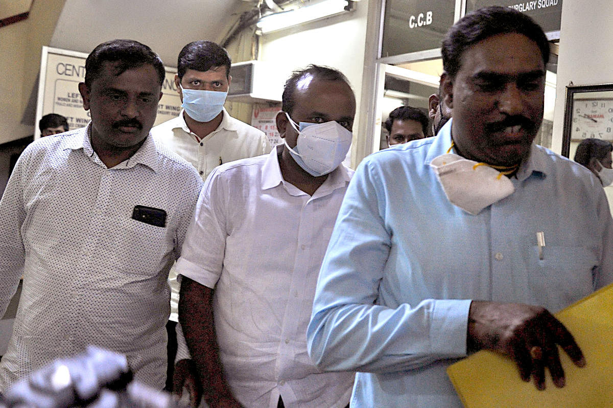 Former mayor R Sampath Raj (wearing a white facemask) after his arrest on November 17 in Bengaluru. DH file PHOTO/PUSHKAR V