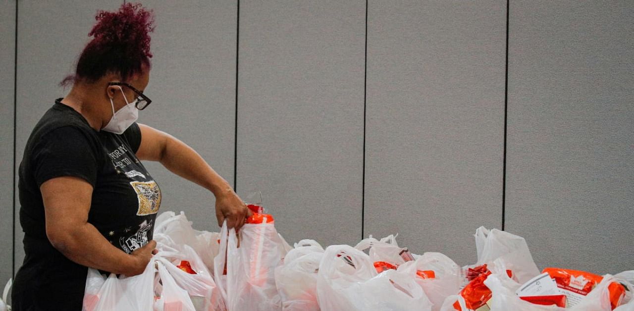 A volunteer prepares bags of free holiday food and Thanksgiving turkeys to those in need at the Central Family Life Center. Credit: Reuters Photo