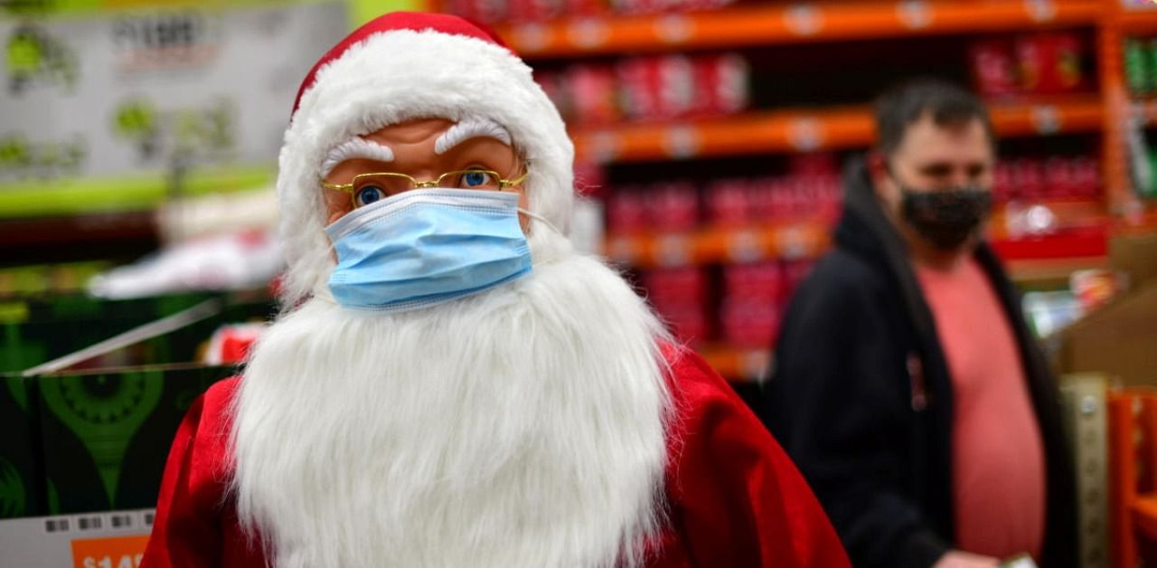A shopper walks past a Santa Claus effigy wearing a face mask due to Covid-19 at a Home Depot store in Wilmington, Delaware. Credit: Reuters Photo