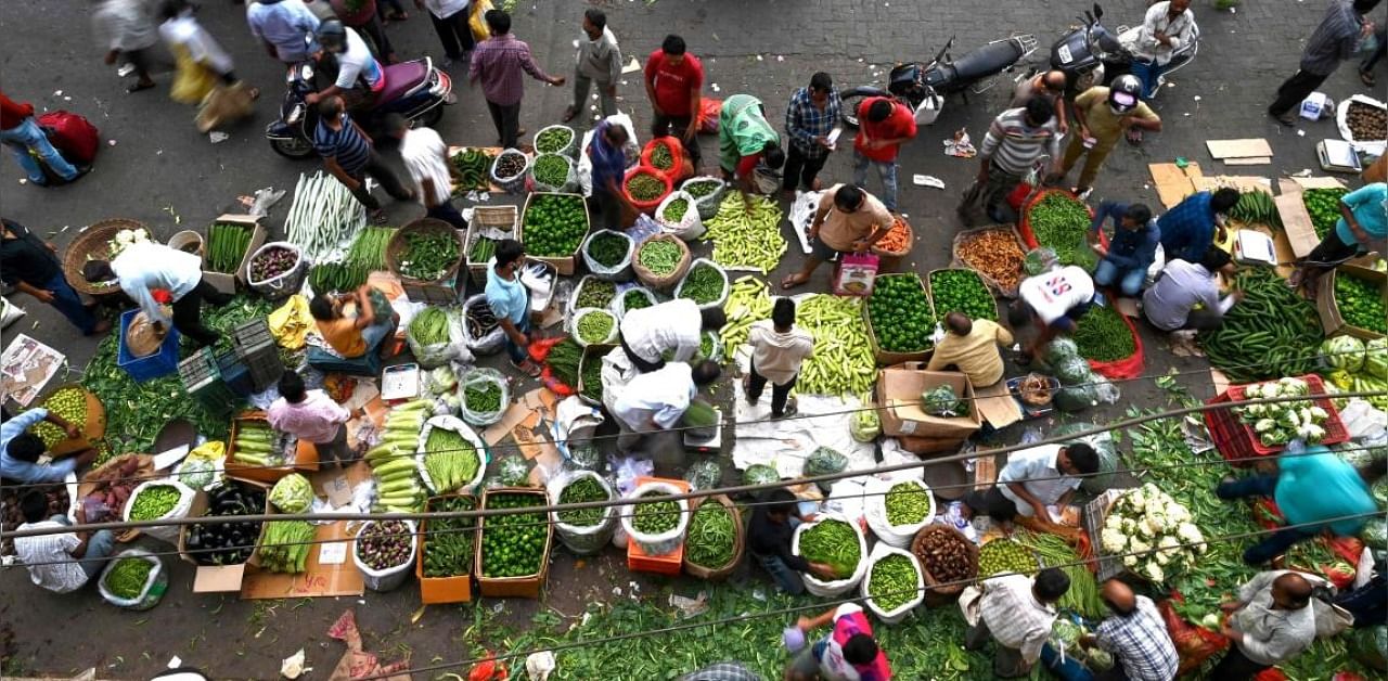 People gather to shop at an open air vegetable market early in the morning in Mumbai. Credit: AFP Photo