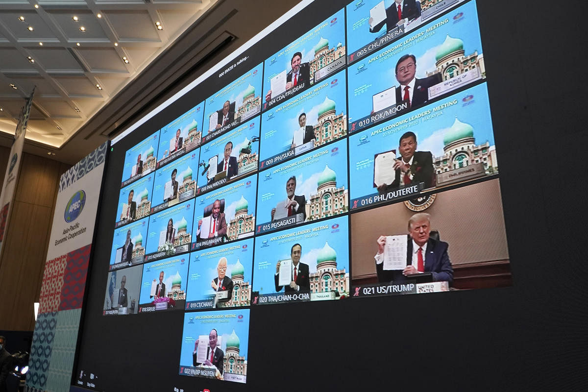 Monitors showing US President Donald Trump, right bottom, hold up declaration together with other leaders attending the first virtual Asia-Pacific Economic Cooperation (APEC) leaders' summit, hosted by Malaysia. Credit: AP/PTI.