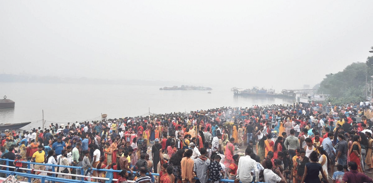 Devotees, flouting social distancing norms, offer prayers to the rising sun after taking bath in the River Ganaga during 'Chhath Puja', in Kolkata. Credit: PTI Photo