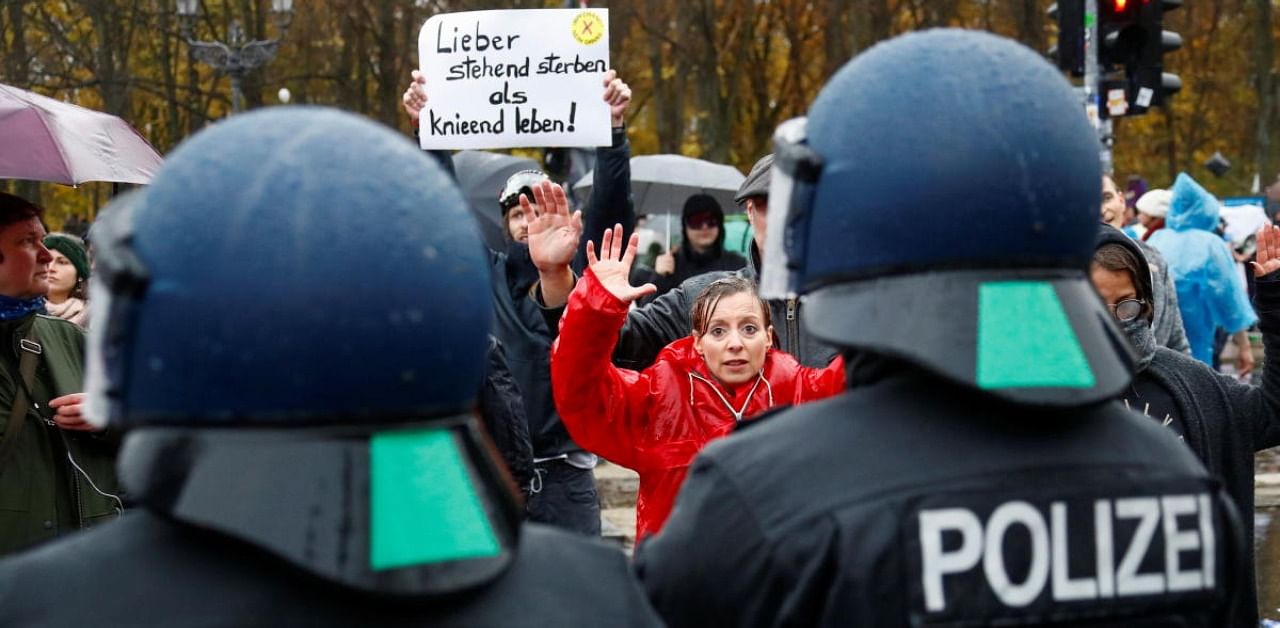 A demonstrator puts her hands up during a protest against the government's coronavirus disease restrictions next to the Brandenburger Gate in Berlin, November, 18, 2020. Credit: Reuters Photo