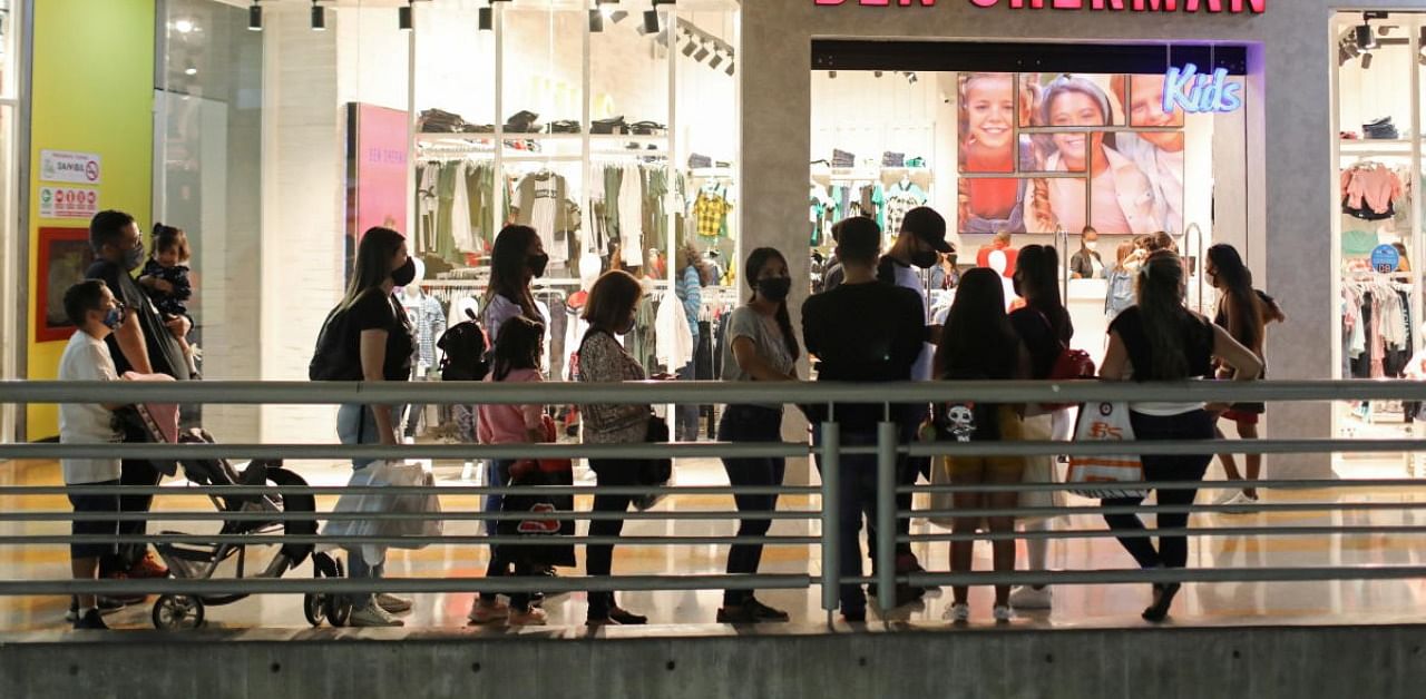People stand in line in front of a shop at a mall during the Black Friday sales. Credit: Reuters Photo