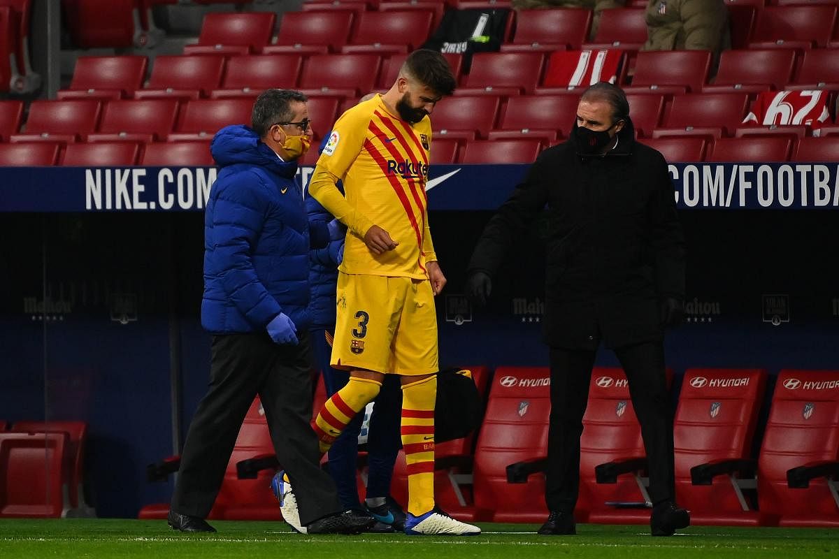 Barcelona's Spanish defender Gerard Pique (C) walks off the pitch after getting injured during the Spanish League football match between Club Atletico de Madrid and FC Barcelona at the Wanda Metropolitano stadium in Madrid on November 21, 2020. Credit: AFP