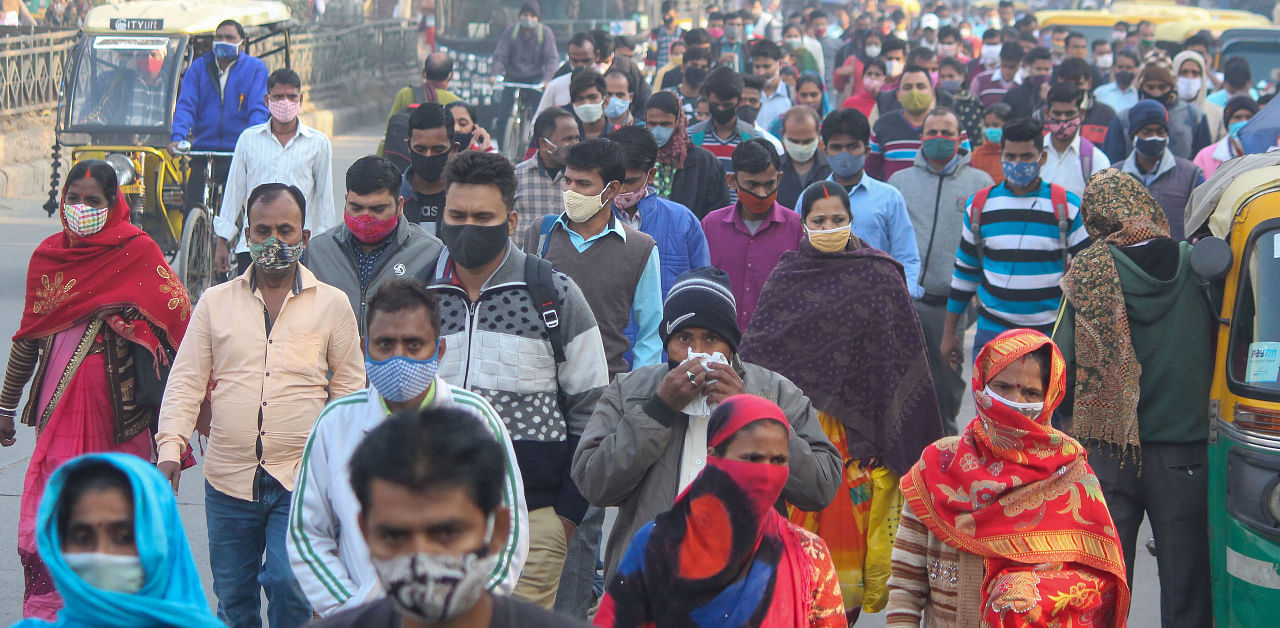 People wearing face masks as a precaution against coronavirus walk along a road on the Dundahera-Kapashera border, in Gurugram, Monday, Nov. 23, 2020. Credit: PTI Photo