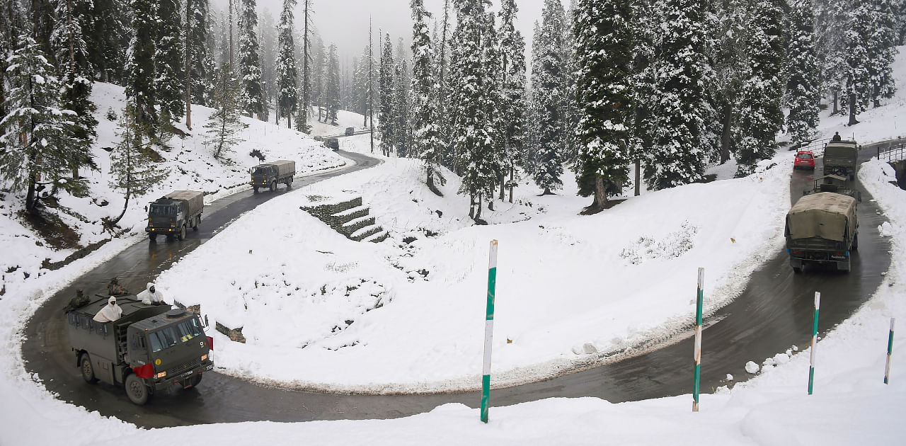 An army convoy moves on a snow covered road after the season's first snowfall, at Gulmarg in Baramulla district of north Kashmir, Monday, Nov. 16, 2020. Authorities have issued an avalanche warning in four districts of the Valley as the higher reaches of the Union Territory received moderate to heavy snowfall, while the plains were lashed by rains. Credit: PTI Photo
