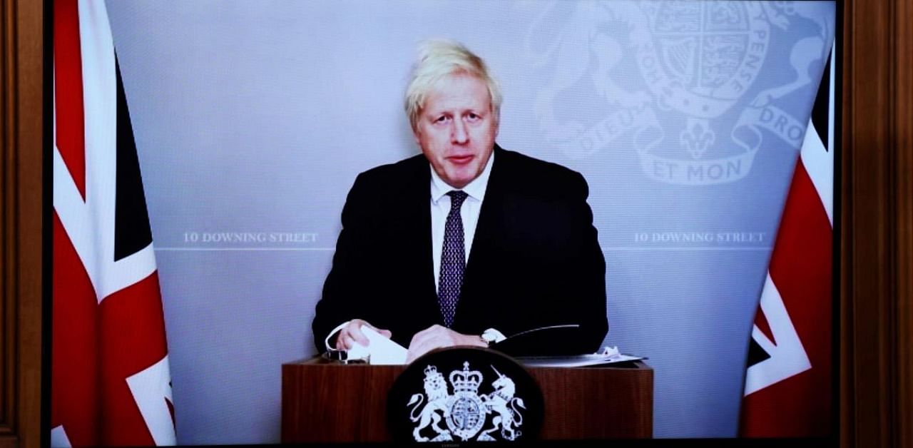 On screen due to self-isolating, Britain's Prime Minister Boris Johnson holds a virtual press conference inside 10 Downing Street in central London. Credit: AFP.