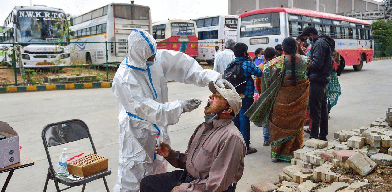  A health worker collects sample for Covid-19 test, at KSRTC bus stand in Bengaluru. Credit: PTI Photo
