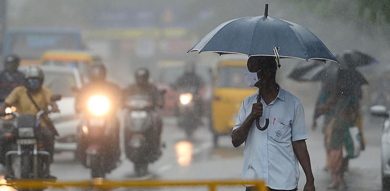 A man walks under an umbrella during heavy rains as cyclone Nivar approaches the eastern Indian coast. Credit: AFP.