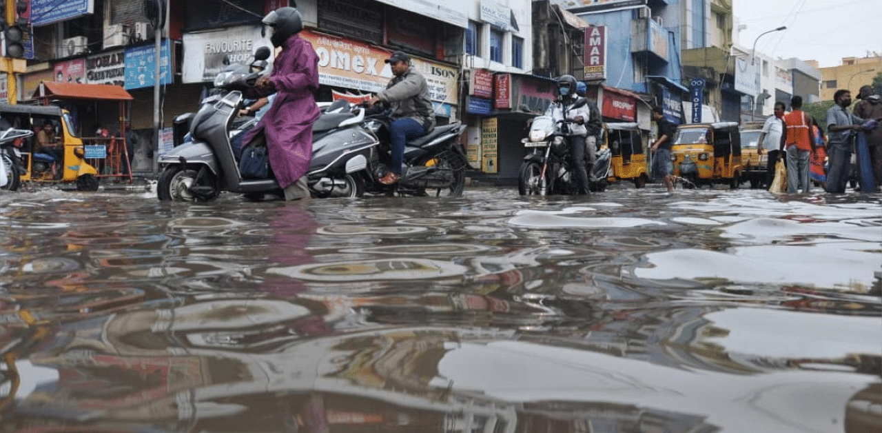   Motorists wade through a water-logged road in Broadway in Chennai on Tuesday. Credit: DH Photo