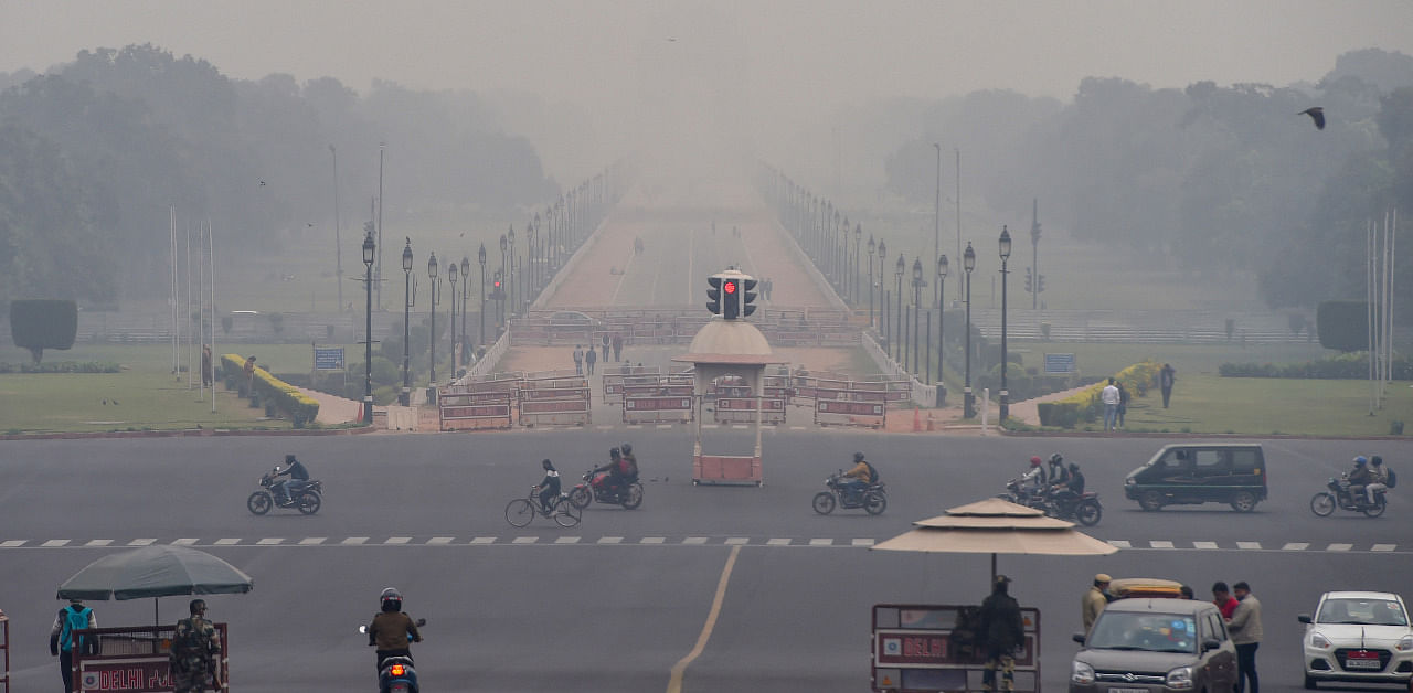 Vehicles ply at Vijay Chowk amid low visibility due to smog, in New Delhi. Credit: PTI Photo
