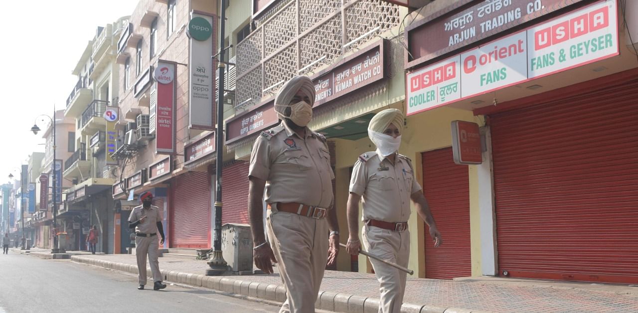 Punjab Police personnel walk near closed shops during Bharat Bandh, a nationwide farmers' strike. Credit: AFP Photo