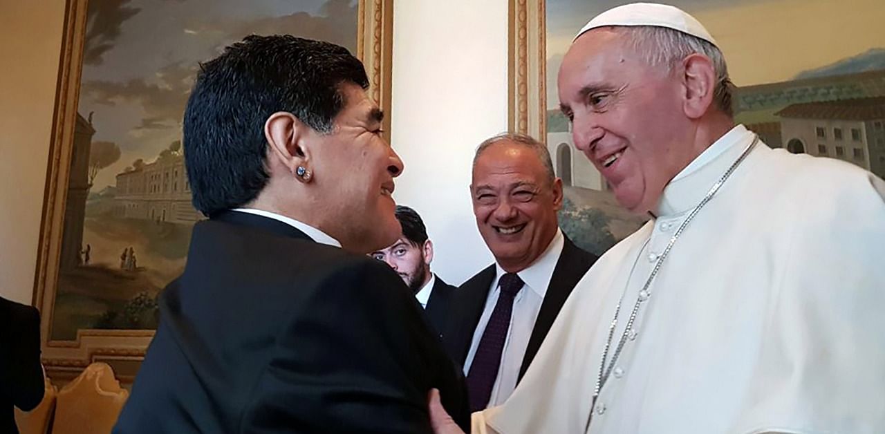 File photo released by Telam of Pope Francis greeting Argentinian retired footballer Diego Maradona (L) at the Vatican City on October 12, 2016. Credit: AFP Photo