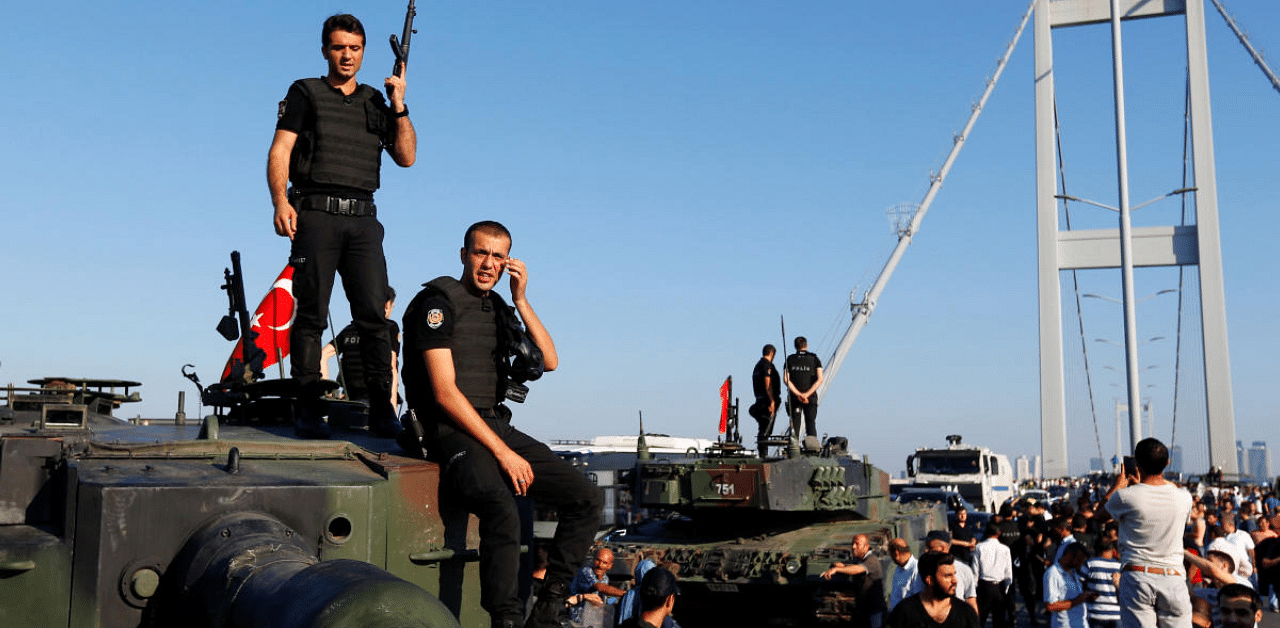 Policemen stand atop military armored vehicles after troops involved in the coup surrendered on the Bosphorus Bridge in Istanbul, Turkey July 16, 2016. Credit: Reuters Photo
