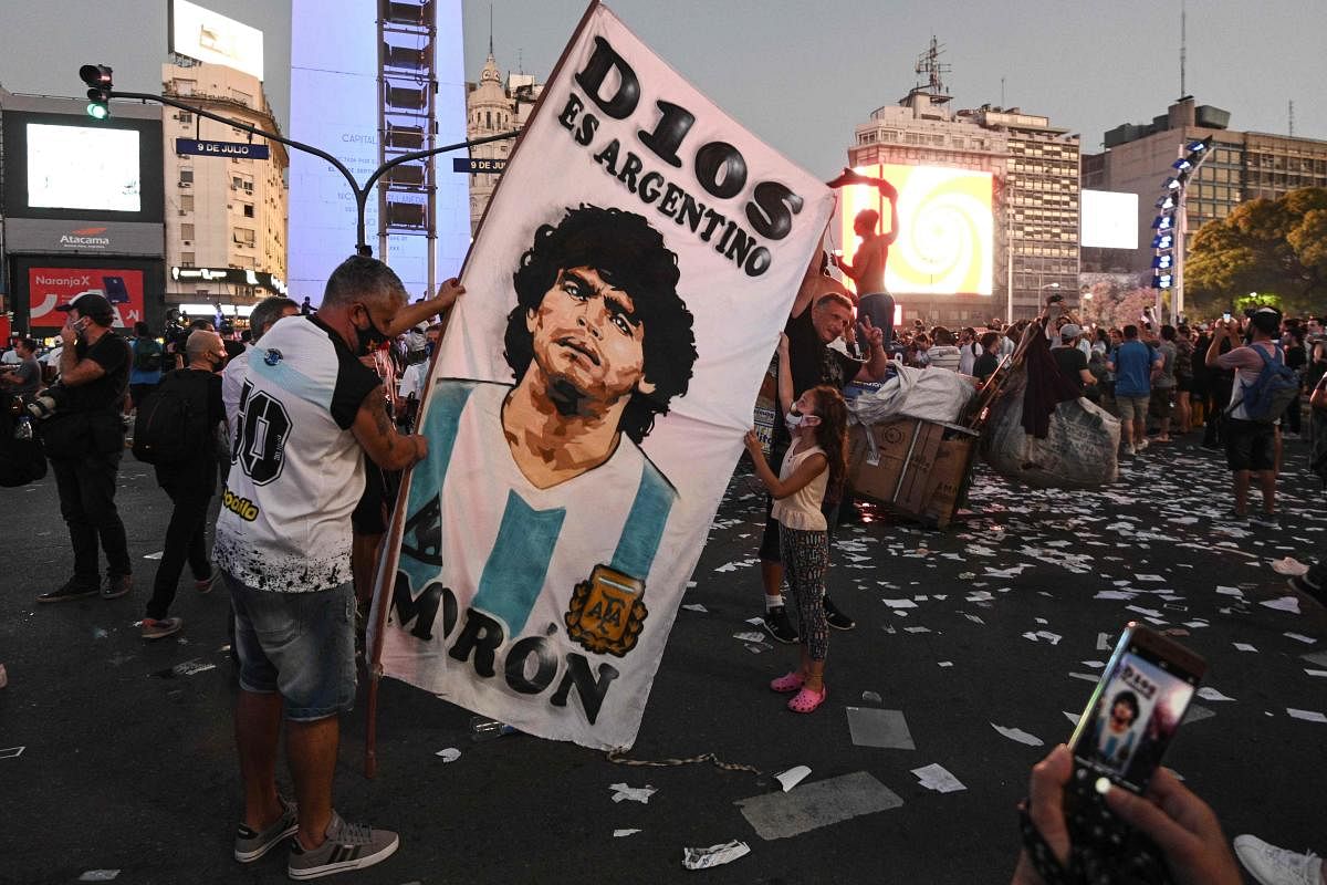 Fans of Argentinian football legend Diego Maradona gather by the Obelisk to pay homage on the day of his death in Buenos Aires. Credit: AFP