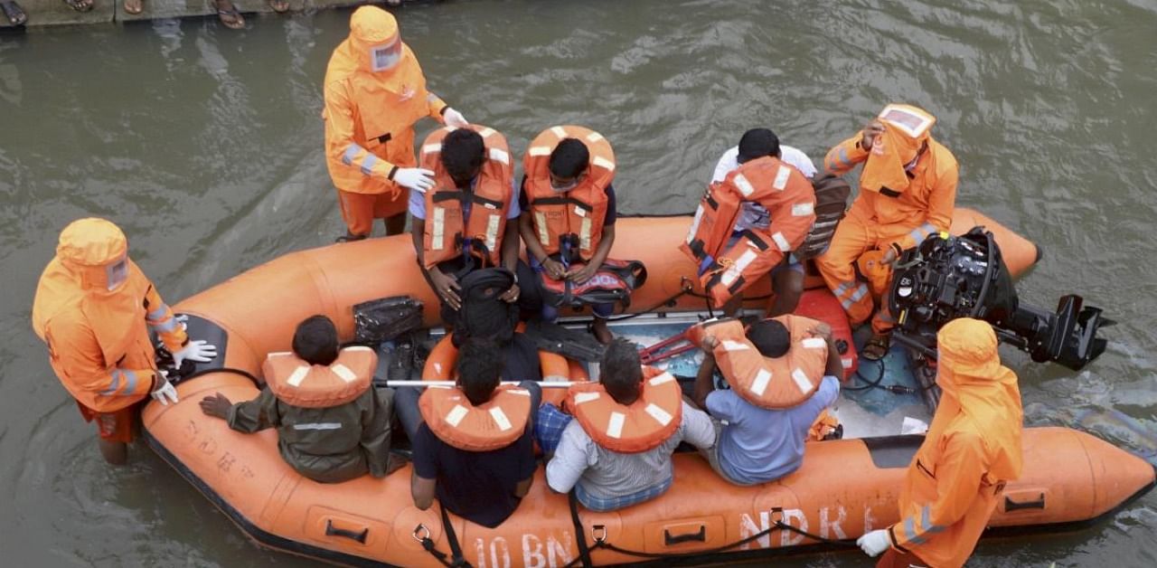NDRF personnel carry out a rescue operation to move locals to safer places after the landfall of Cyclone Nivar, at Mudichur in Chennai. Credit: PTI.