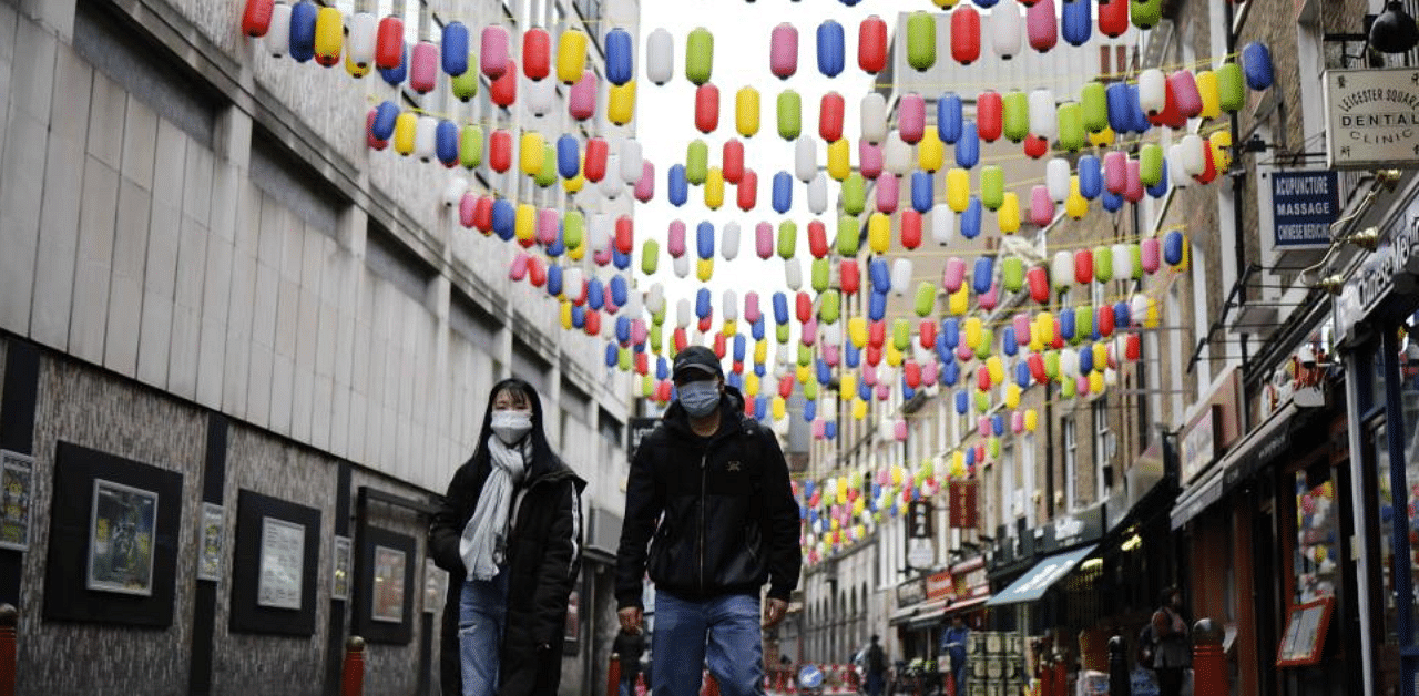 People wearing a face mask because of the coronavirus pandemic walk in London's China Town on November 25, 2020. Credit: AFP Photo