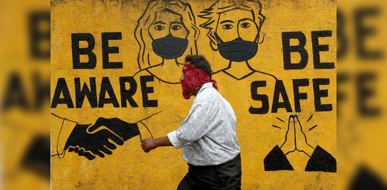 A man walks past a graffiti amid the spread of the coronavirus disease in Mumbai, India, November 2, 2020. Credit: Reuters Photo