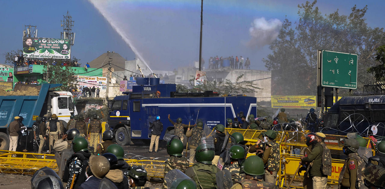A water cannon spray appears as a rainbow as police personnel try to disperse farmers heading towards Delhi during their 'Delhi Chalo' protest march against the new farm laws, at Kundli border in Sonepat. Credit: PTI Photo