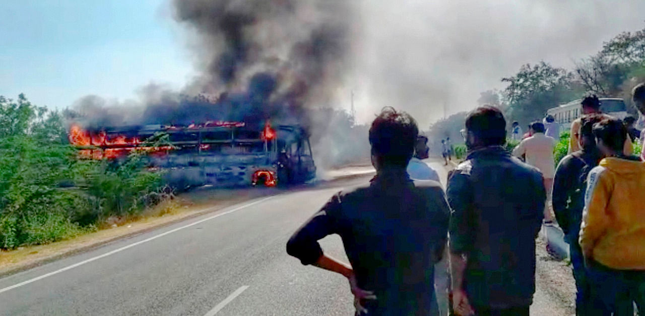 People look at the sleeper coach bus which caught fire on the Delhi -Jaipur Highway near Achrol Village, in Jaipur. Credit: PTI Photo
